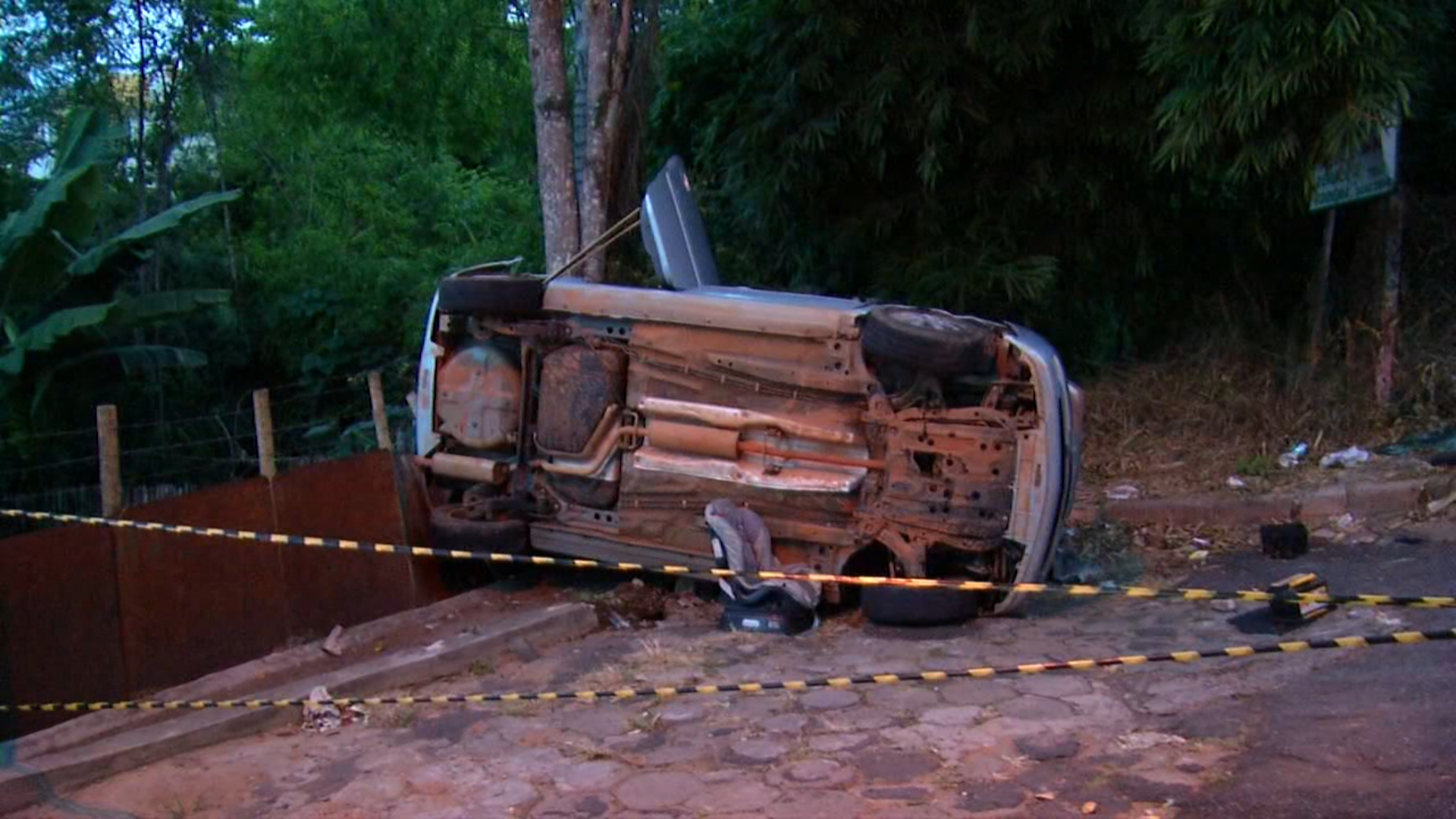 Desgovernado: carro perde controle, invade cerca e tomba
